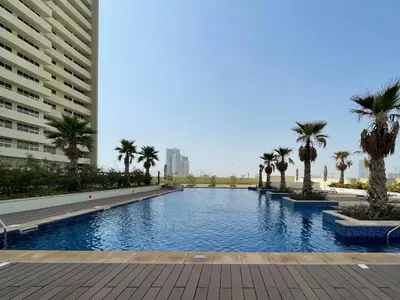 a swimming pool with palm trees and a building at The Smart Concierge - Damac 108 in Dubai
