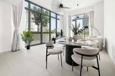 a white living room with a table and chairs at Jumeirah Waterfront Residences in Dubai