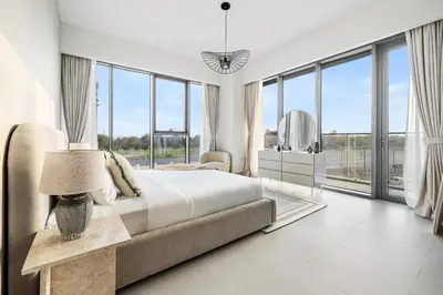a white bedroom with a bed and a mirror at Jumeirah Waterfront Residences in Dubai