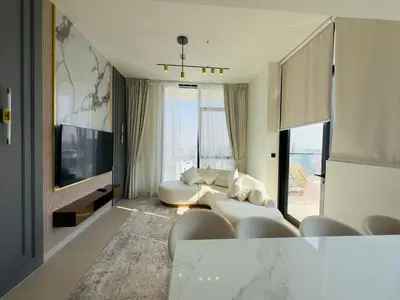 a living room with a white couch and a tv at High-End Furnished Homey Elegant with Private Pool in Dubai