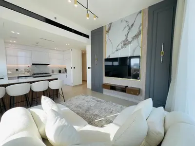 a living room with a white couch and a kitchen at High-End Furnished Homey Elegant with Private Pool in Dubai