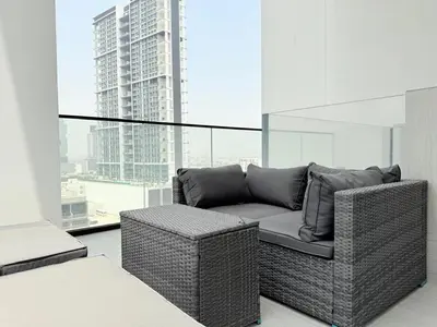 a wicker couch in a room with a large window at Brand New with Installed Private Pool in Balcony in Dubai