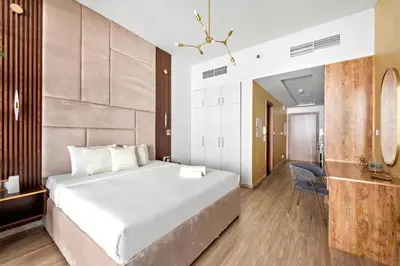 a bedroom with a large white bed and a chair at Stylish Furnished Apartment with Burj Khalifa View, High Floor in Dubai