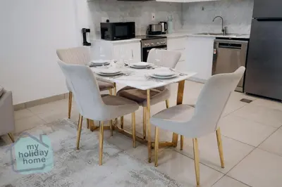 a kitchen with a table and chairs in a kitchen at Luxurious Apartment in the Heart of Dubai in Dubai