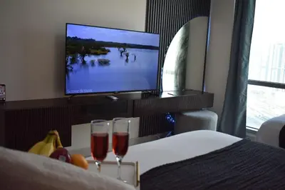 a hotel room with two wine glasses and a tv at Cozy 2BR -Near JBR Beach &Metro in Dubai