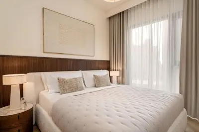 a bedroom with a large white bed and a window at Seraya Residence 20 - 4BDR - Burj View with direct access to Dubai Mall in Dubai