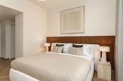 a bedroom with a large white bed with two lamps at Seraya Residence 21 - 4BDR - Cozy terrace with Burj Views in Dubai