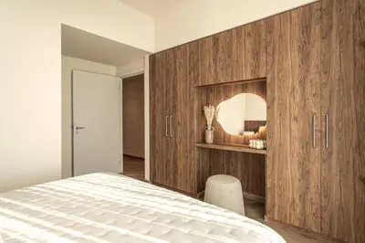 a bedroom with a large wooden cabinet with a mirror at Seraya Residence 21 - 4BDR - Cozy terrace with Burj Views in Dubai