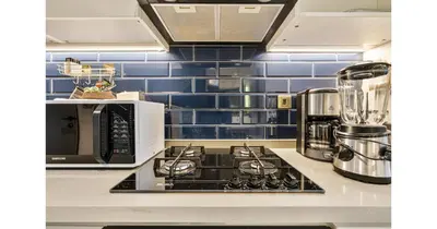 a kitchen with a stove top oven next to a microwave at Stylish Studio - 5-min walk Burj Khalifa & Dubai Mall in Dubai