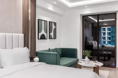 a bedroom with a bed and a green chair at Luxury Studio Near Beach and Sea in Dubai Marina in Dubai