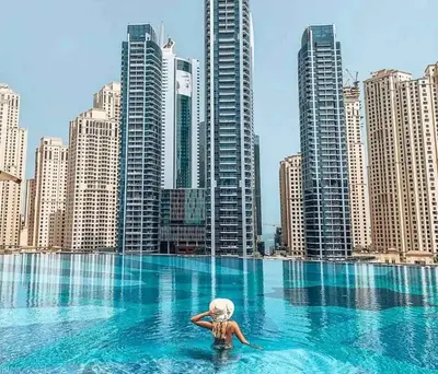 a woman in a pool in a city with tall buildings at Luxury Studio Near Beach and Sea in Dubai Marina in Dubai