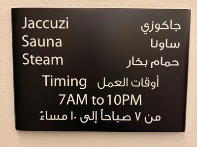 a black sign with white writing on a wall at Luxury Studio Near Beach and Sea in Dubai Marina in Dubai
