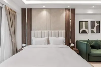 a bedroom with a large white bed and a green chair at Luxury Studio Near Beach and Sea in Dubai Marina in Dubai