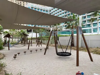 a swing set in a playground in a building at Stylish 1BR Apartment in JBR with Beach Access & Dubai Marina Views in Dubai
