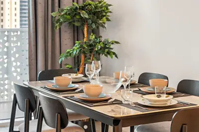 a wooden table with chairs and a table with glasses at Stylish 1BR Apartment in JBR with Beach Access & Dubai Marina Views in Dubai