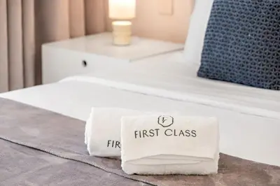 a white first class towel on a bed at Stylish 1BR Apartment in JBR with Beach Access & Dubai Marina Views in Dubai