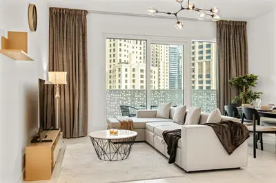 a living room with a couch and a table at Stylish 1BR Apartment in JBR with Beach Access & Dubai Marina Views in Dubai
