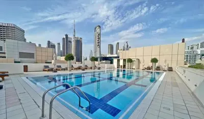 a large swimming pool on the roof of a building at Dubai 1BR City Views, Near Downtown Dining, Culture & Attractions in Dubai
