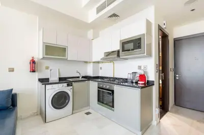 a kitchen with a washing machine and a washer at Business Bay, Compact, Modern Studio Dubai in Dubai