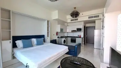 a large bedroom with a large bed and a kitchen at Business Bay, Compact, Modern Studio Dubai in Dubai