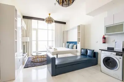 a living room with a couch and a washing machine at Business Bay, Compact, Modern Studio Dubai in Dubai