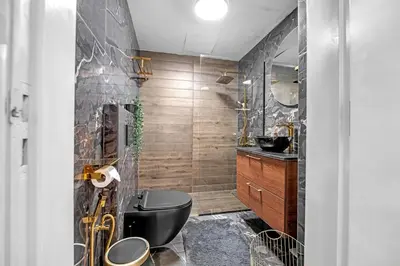 a bathroom with a black toilet and a sink at Waves - Gold Opulence 1 BR in Marina in Dubai