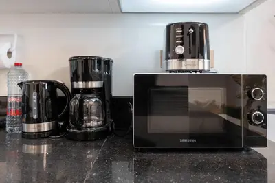 a microwave sitting on top of a kitchen counter at 2BR Waterfront Apartment Nr Downtown in Dubai