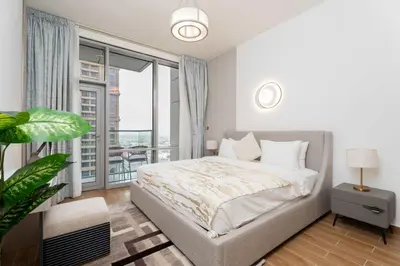 a bedroom with a bed and a large window at 2BR Waterfront Apartment Nr Downtown in Dubai