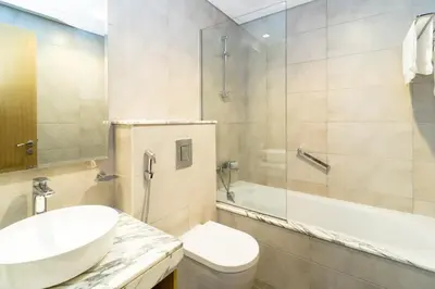 a bathroom with a sink and a toilet and a shower at Cozy 2BR Pool & City Views in Dubai