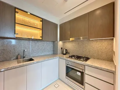 a kitchen with white cabinets and a sink at Modern & Cozy 1BR with Great Amenities, Grand Bleu in Dubai