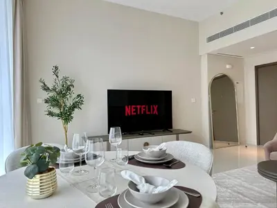 a living room with a table and a tv at Modern & Cozy 1BR with Great Amenities, Grand Bleu in Dubai