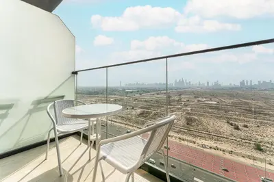 a table and chairs on a balcony with a view at HAVN - High Floor Studio in Bloom Towers, JVC in Dubai