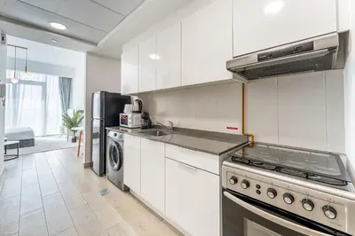a kitchen with a stove and a refrigerator at HAVN - High Floor Studio in Bloom Towers, JVC in Dubai