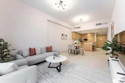 a living room with a couch and a table at HAVN - 1 Spacious Bedroom in Belgravia 1, JVC in Dubai