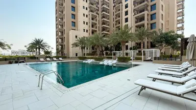 a swimming pool with lounge chairs and a building at Luxury apartment with Iconic Landmark View, pool, gym, free parking in Dubai
