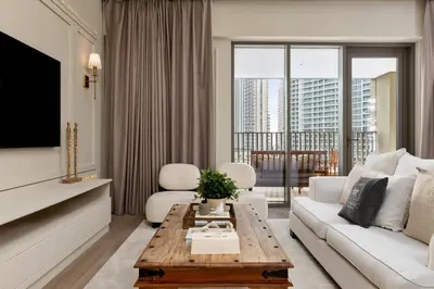 a living room with a white couch and a table at Maison Privee - Creekside Elegance with Canal Vws at Creek Beach in Dubai