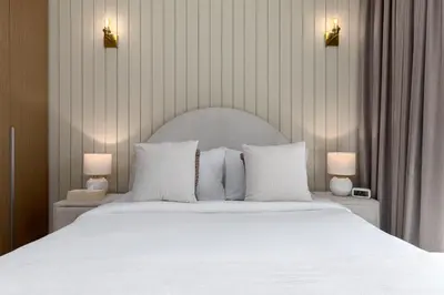 a bedroom with a white bed with two lamps at Maison Privee - Creekside Elegance with Canal Vws at Creek Beach in Dubai
