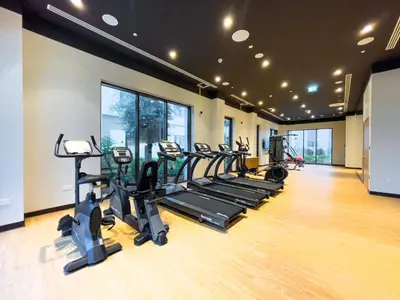 a gym with a row of treadmills and ellipticals at Maison Privee - Creekside Elegance with Canal Vws at Creek Beach in Dubai