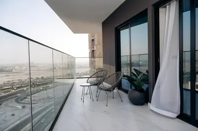a balcony with chairs and tables on a building at Amazing brand new 2BR - Business Bay-Binghatti in Dubai