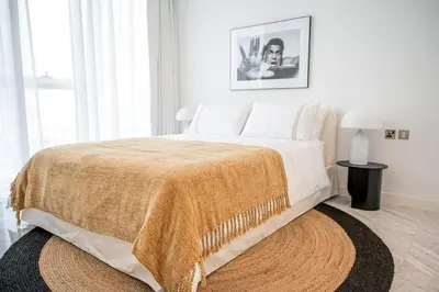 a bedroom with a large bed with a blanket on it at Luxurious Lake View 1BR - Business Bay - Pool - Gym in Dubai