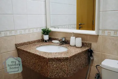 a bathroom sink with a mirror and a toilet at Beautiful 1BR-Fully Furnished- Balcony-Pool & Gym in Dubai