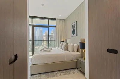 a bedroom with a large bed and a large window at Bright 1 Bedroom with Burj Khalifa view in Peninsula in Dubai