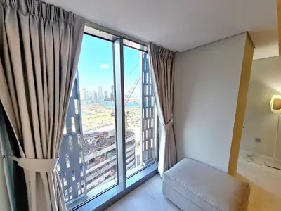a room with a large window with a view of a city at Luxury 2BR in Cayan Tower with Stunning Views in Dubai