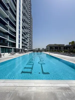 a large swimming pool in front of a building at Stunning 1BR in Binghatti Corner, JVC in Dubai