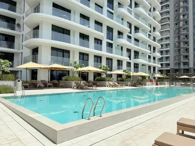 a swimming pool in front of a building at Luxury & Bright 1BR Apartment | Panoramic Sea View in Dubai