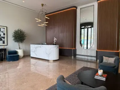 a living room with a table and chairs and a lobby at Luxury & Bright 1BR Apartment | Panoramic Sea View in Dubai