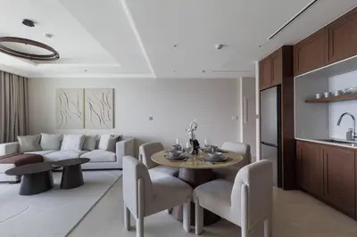 a living room with a couch and a table and chairs at Luxury & Bright 1BR Apartment | Panoramic Sea View in Dubai