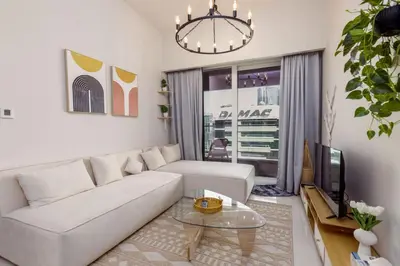a living room with a white couch and a tv at Tropical Nest in Dubai