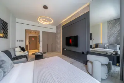 a bedroom with a bed and a living room at Grove Luxurious Stu Best community Art & Design in Dubai