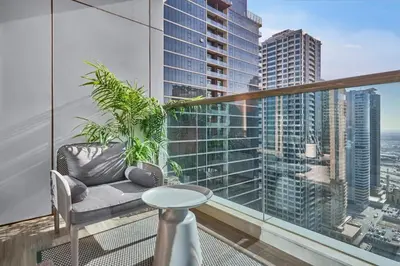 a balcony with a couch and a view of a city at Sky-High Luxury 1BR in 27th Floor MBL Residence in Dubai